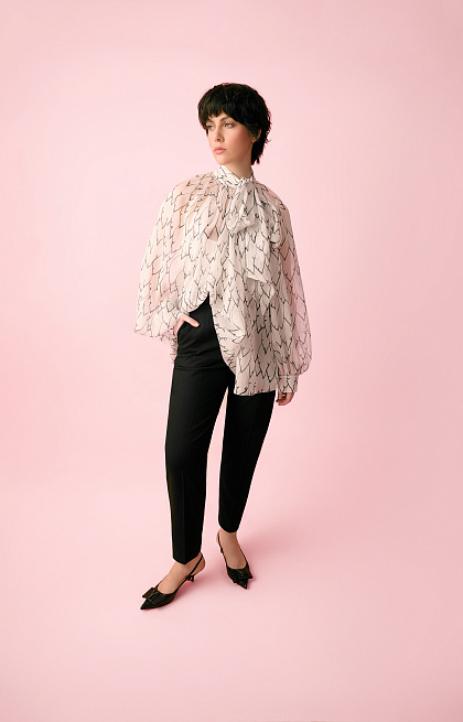 A white chiffon blouse with an author's print